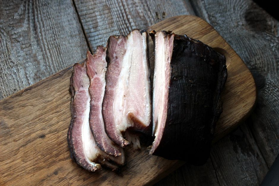 smoked bacon and sausage on wooden cutting board rustic kitchen