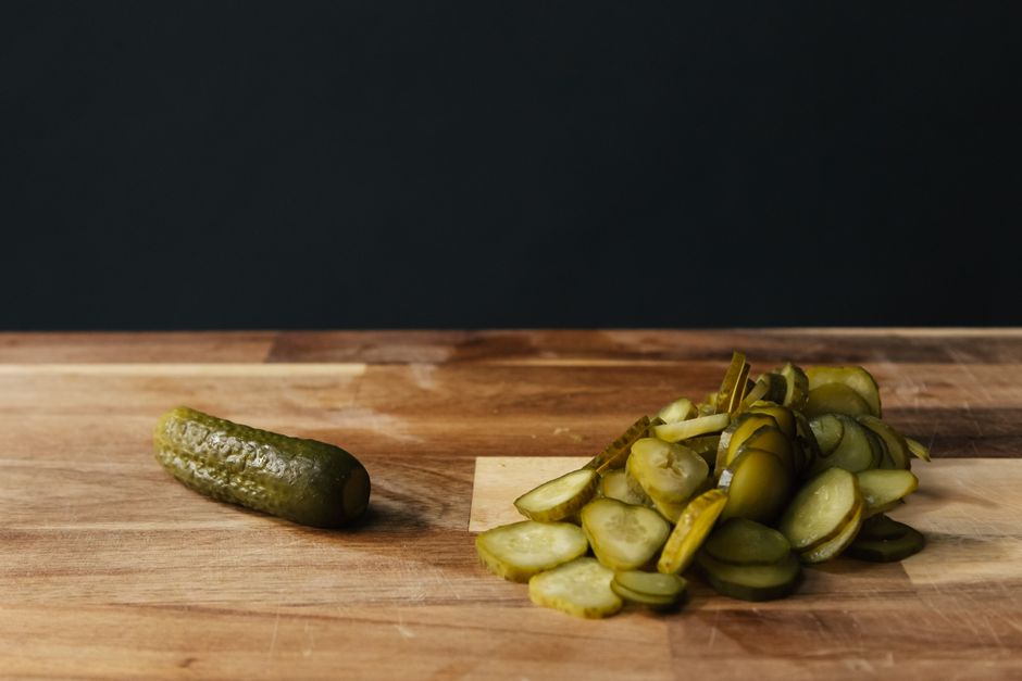 pickled cucumbers sliced on wooden board