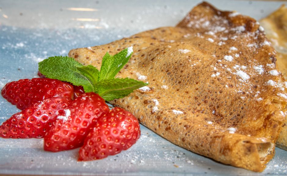 folded crepes with berries and powdered sugar