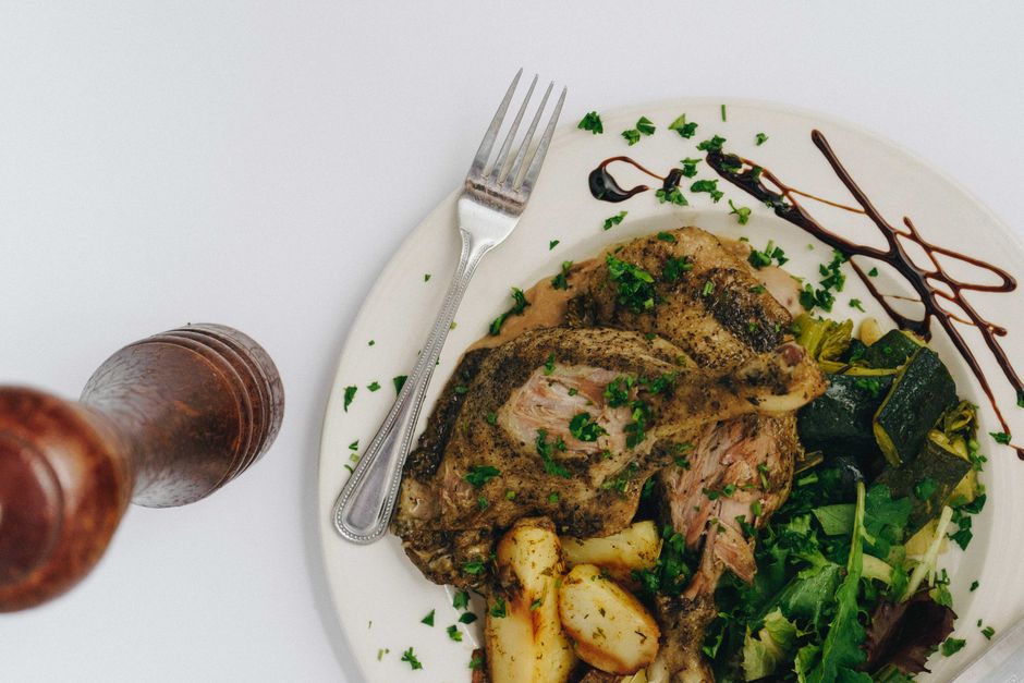 juicy baked chicken with potatoes and peppers on plate