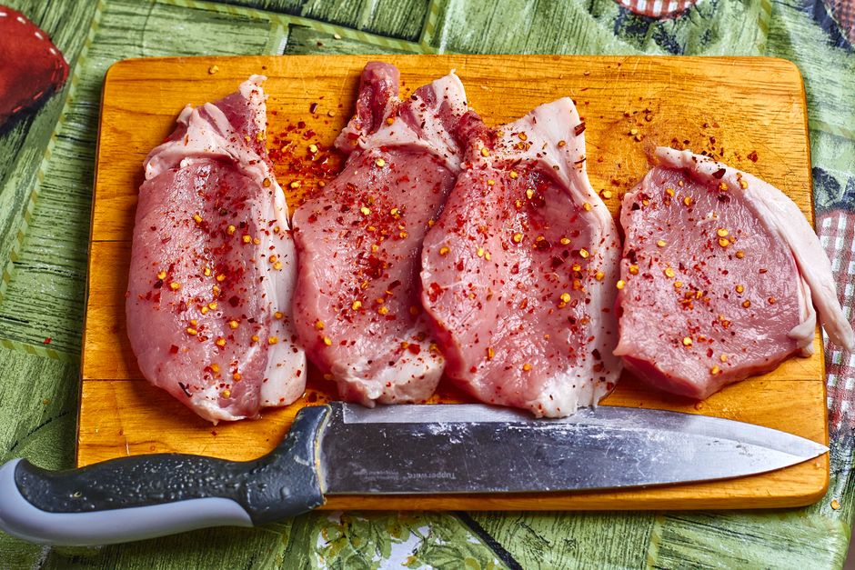 raw pork shoulder meat pieces cutting board knife
